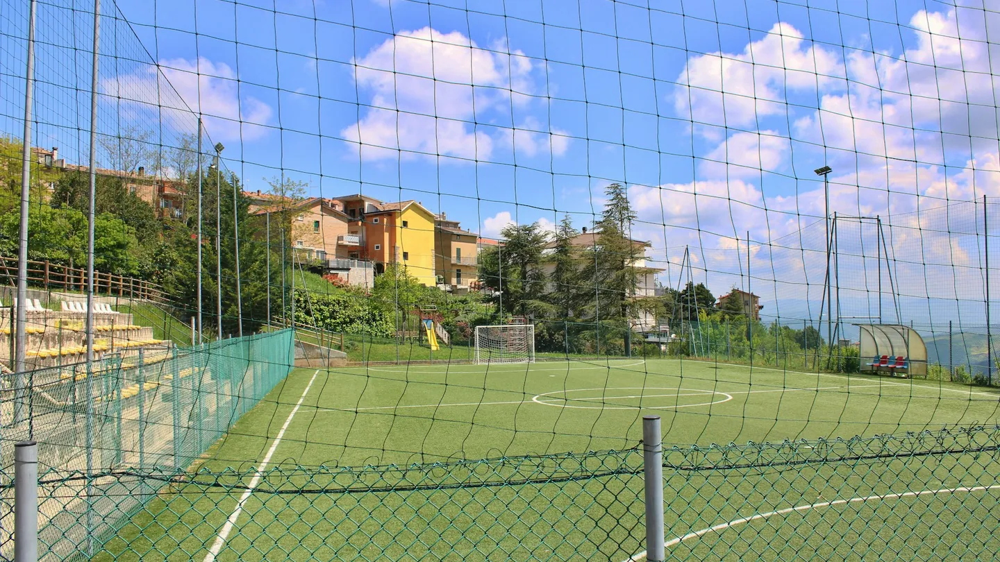 Una cancha de fútbol con césped artificial y redes.